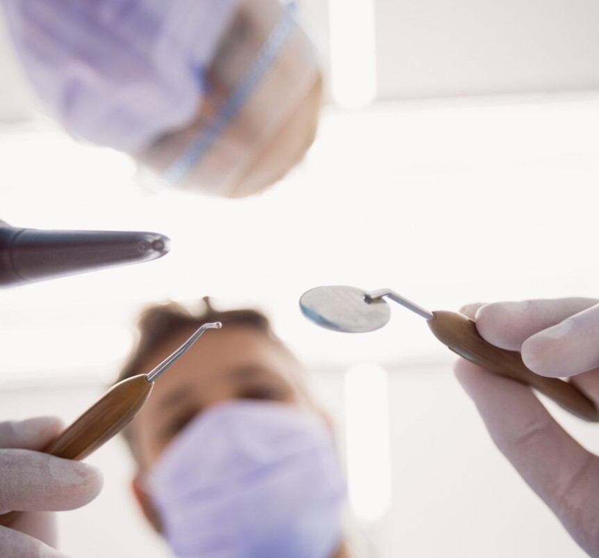 Vista cenital de dos dentistas tratando a un paciente