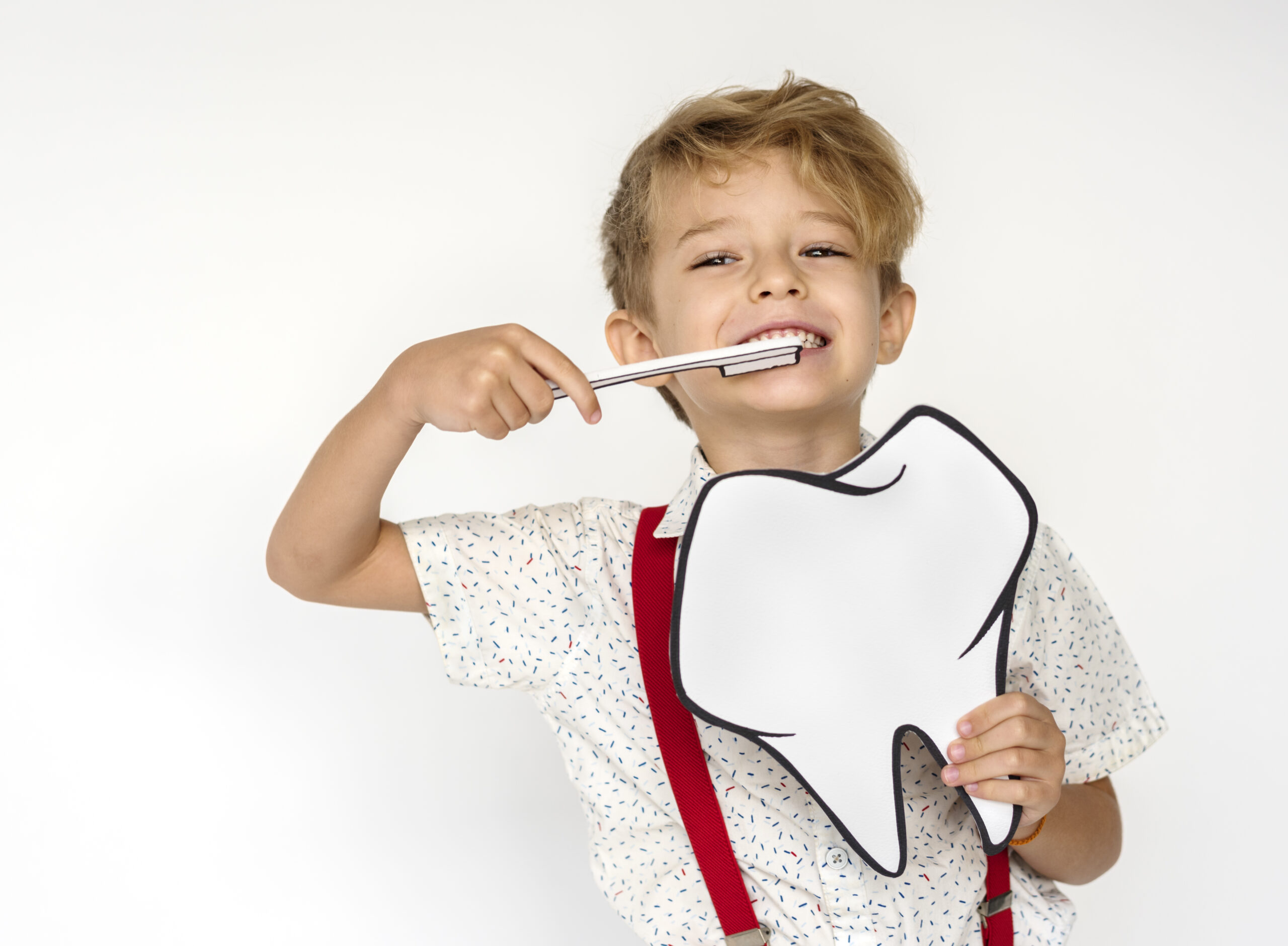 Niño sonriendo mientras se cepilla los dientes