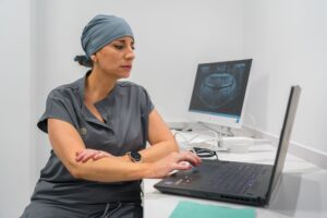 Dentista mirando un ordenador con radiografía de un paciente